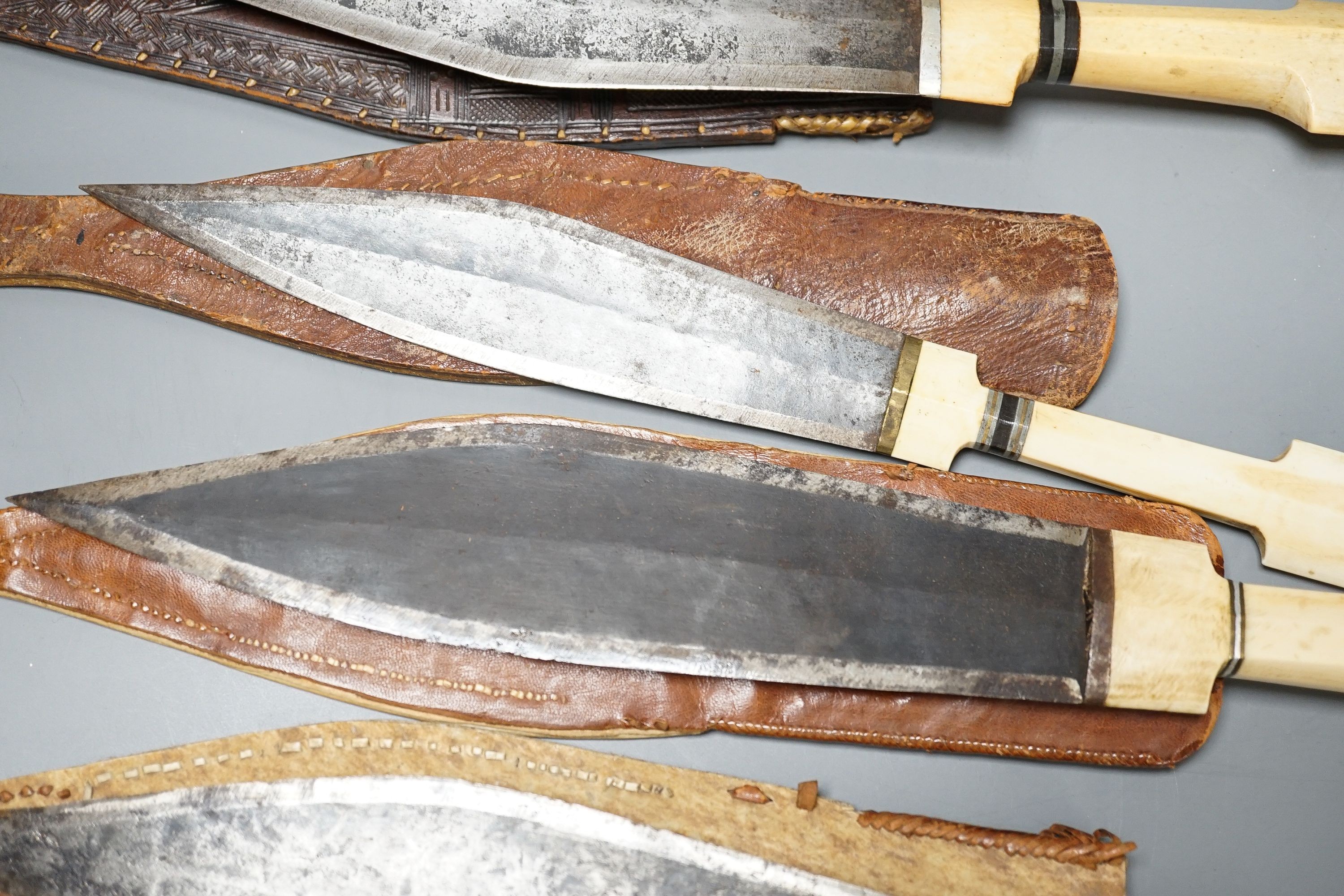 Four similar African tribal daggers c.1900, each with hippo tusk handle including two with silver pommels, all in their decorated leather scabbards with 1 belt, maximum 45cms.